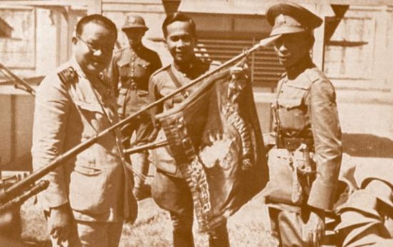 Plaek Phibunsongkhram, The prime minister of Thailand during WW2, observing the army flag of the 2nd Foreign Infantry Regiment, after defeating France at Phum Preav.